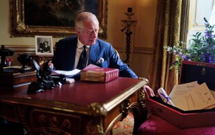 Le roi Charles III ouvrant une boite rouge à Buckingham