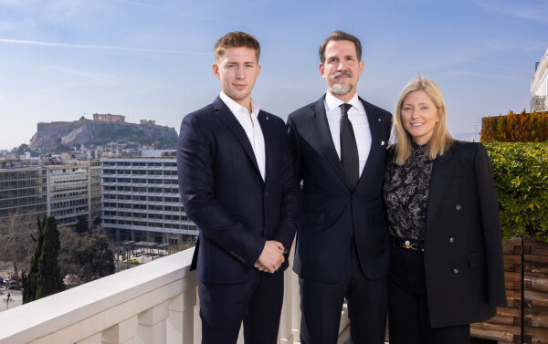 Le prince Pavlos de Grèce entouré de son fils aîné, le diadoque Constantin, et de son épouse, la princesse Marie-Chantal, avec en arrière-plan, l’Acropole d’Athènes.