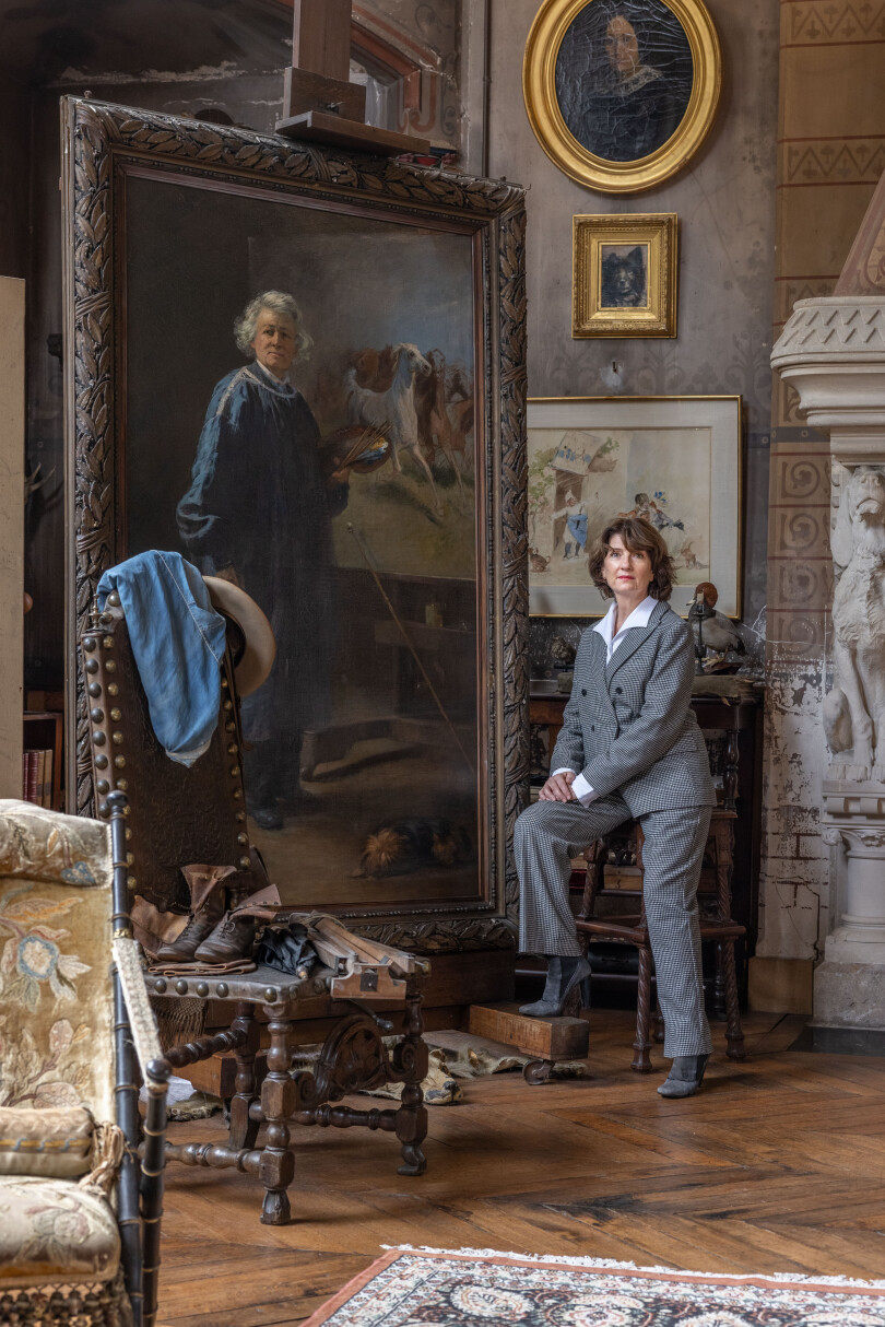 La nouvelle propriétaire du château de By, Katherine Brault, pose devant le portrait de l'ancienne maîtresse des lieux, Rosa Bonheur.