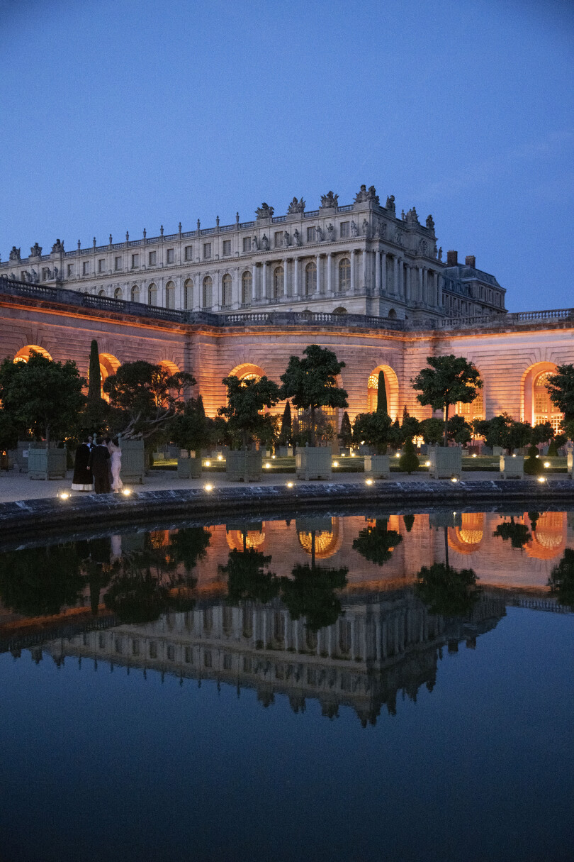 Tandis que la nuit tombe sur le château de Versailles, l’Orangerie brille de tous ses feux.