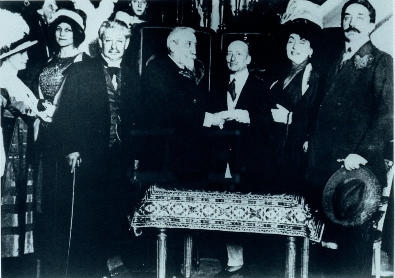 Chapeau à la main, Robert de Montesquiou photographié à Paris aux côtés (de droite à gauche) de l’artiste Madeleine Lenoir, de l’écrivain et prince de Montenevoso Gabriele D’Annunzio, des écrivains Anatole France et Georges Brandes.