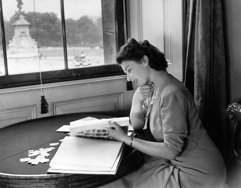 La princesse Élisabeth examine sa collection de timbres à Buckingham en juillet 1946.
