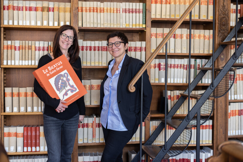 Charlotte Denoël, tenant dans ses bras un exemplaire du Beatus, édité en fac-similé chez Citadelles & Mazenod, et Isabelle Marchesin, spécialiste des images du premier Moyen Âge.