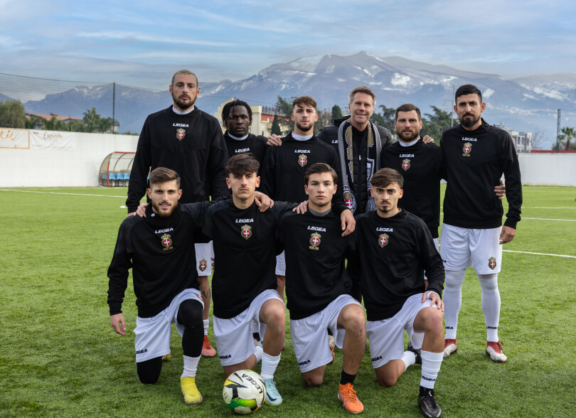Le prince pose au milieu de son équipe, au pied des montagnes de Campanie.