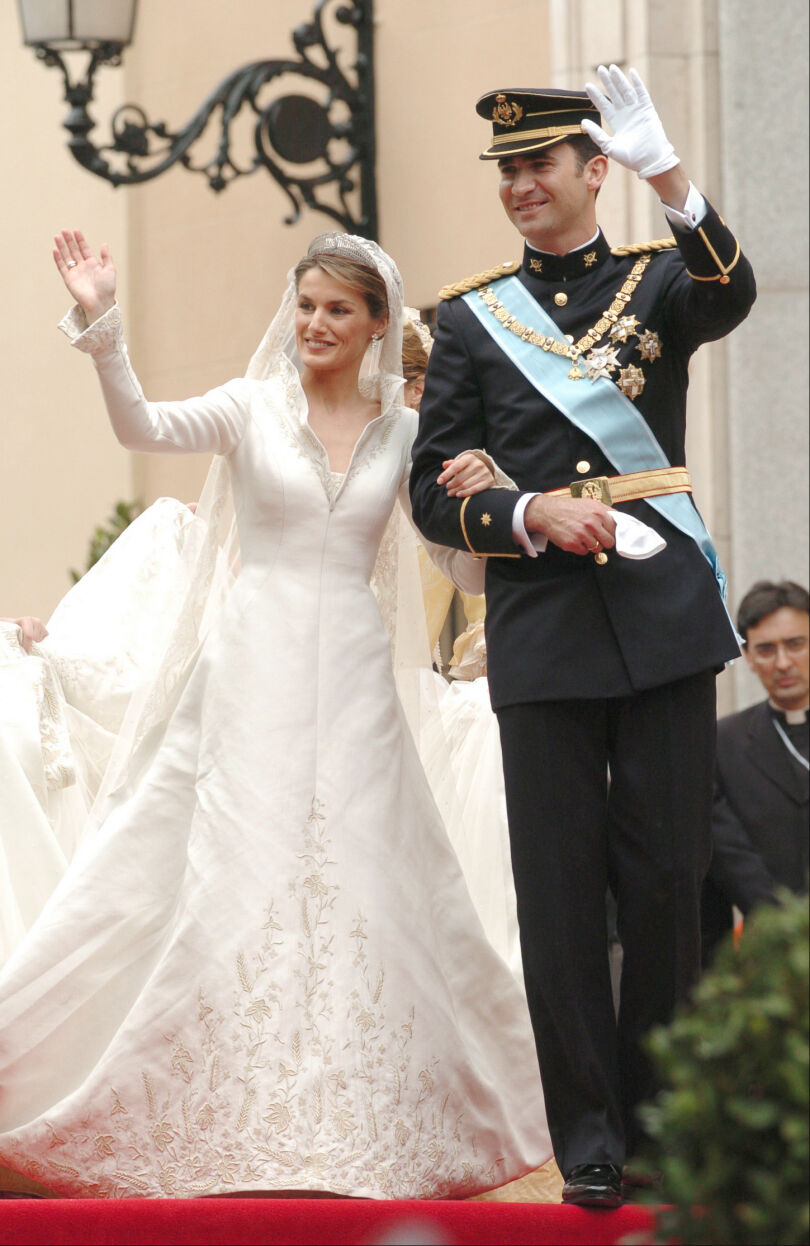 Felipe VI épouse Letizia d'Espagne le 22 mai 2004. Pour son mariage, Letizia porte une robe signée Manuel Pertegaz avec une traîne de plus de 4 mètres de long. Rebrodée de motifs végétaux en fils d'or, cette robe va à merveille à la belle espagnole.